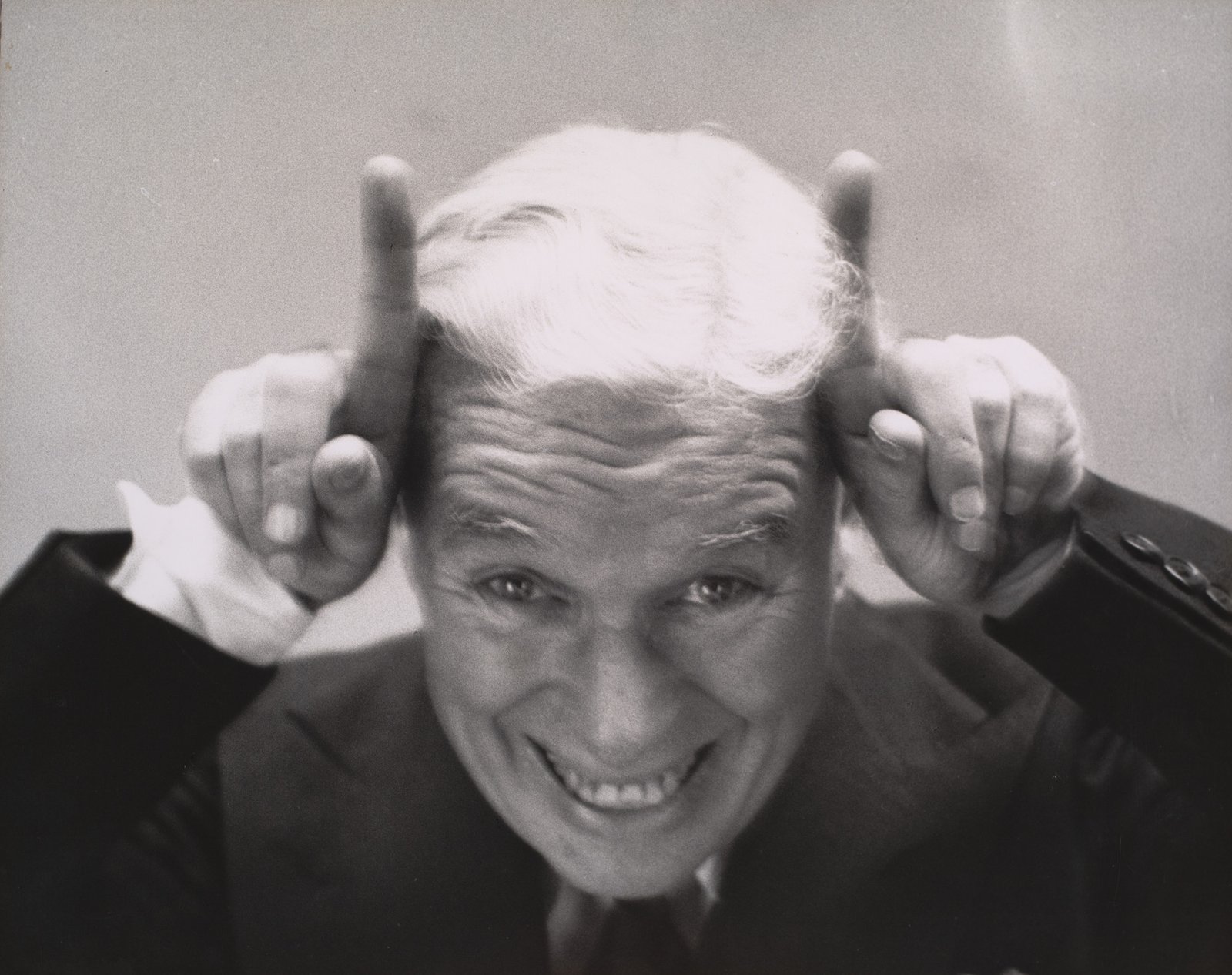 Charles Chaplin haciendo cuernos con los dedos, retrato de Richard Avedon, 1952